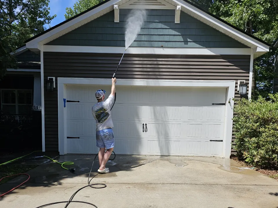 Spraying and rinsing the siding above a garage door