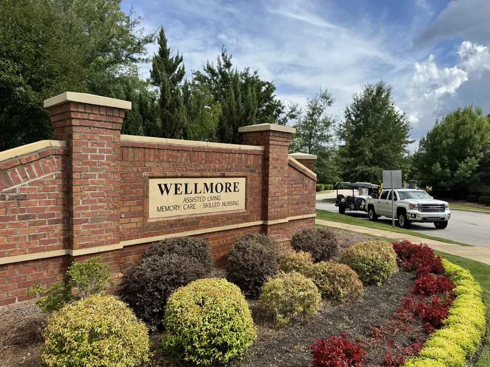 Brick monument sign at a senior living community after cleaning, with the Lake Murray Soft Wash truck and trailer in the background