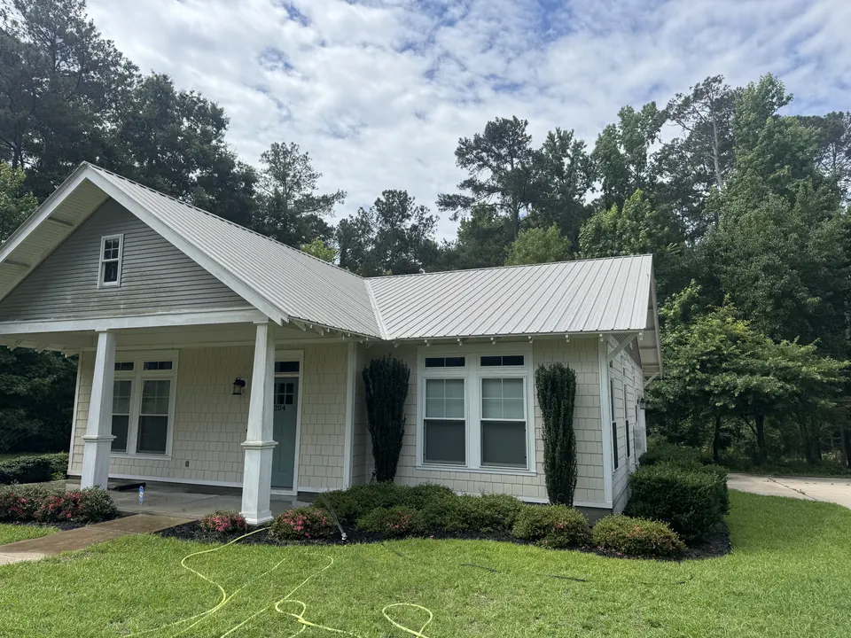 Same cottage with a clean roof and fresh siding after cleaning