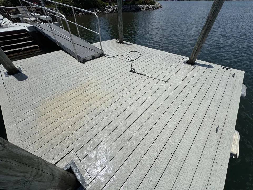 Gray composite dock deck on Lake Murray with stained, dingy boards before cleaning