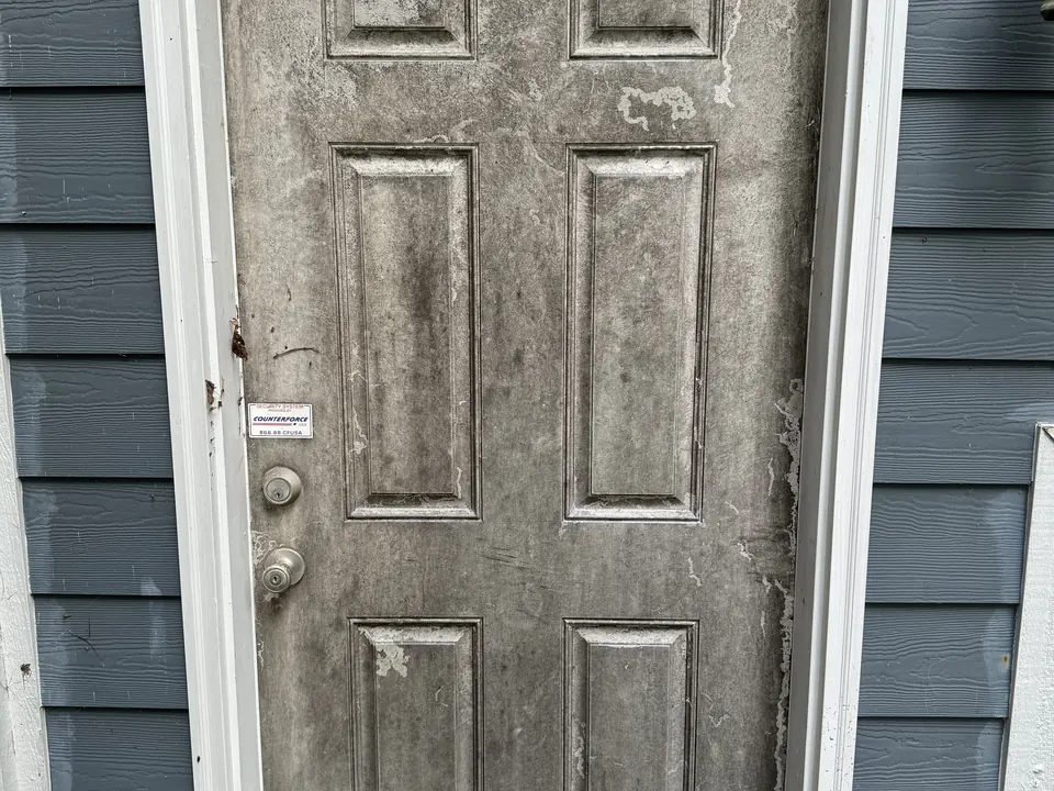 Dirty, mildewed exterior door before cleaning