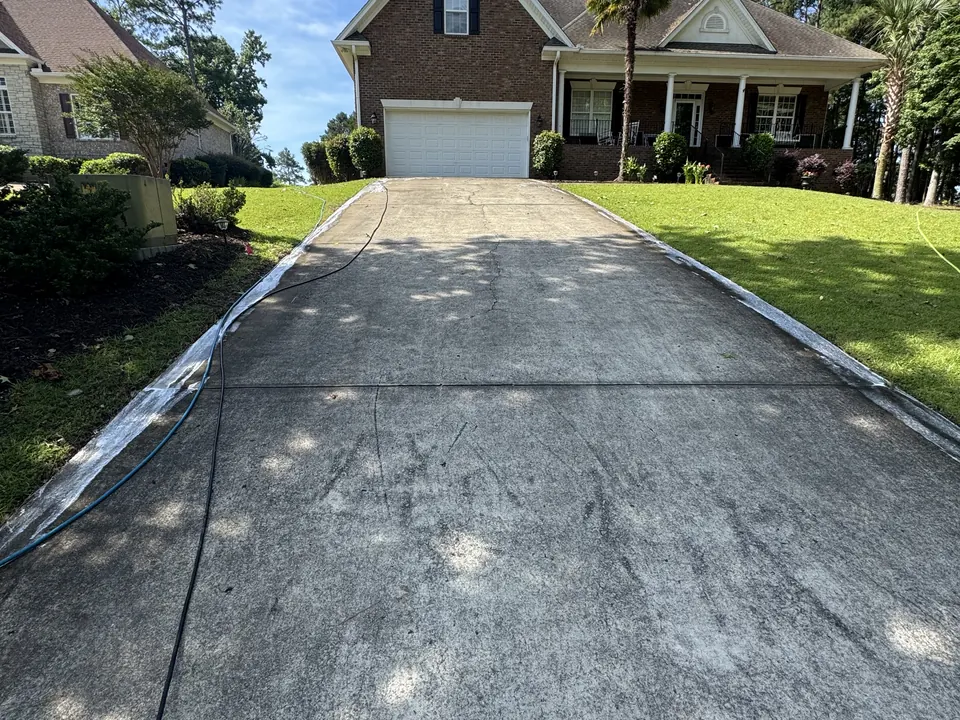 Dark, stained concrete driveway before cleaning