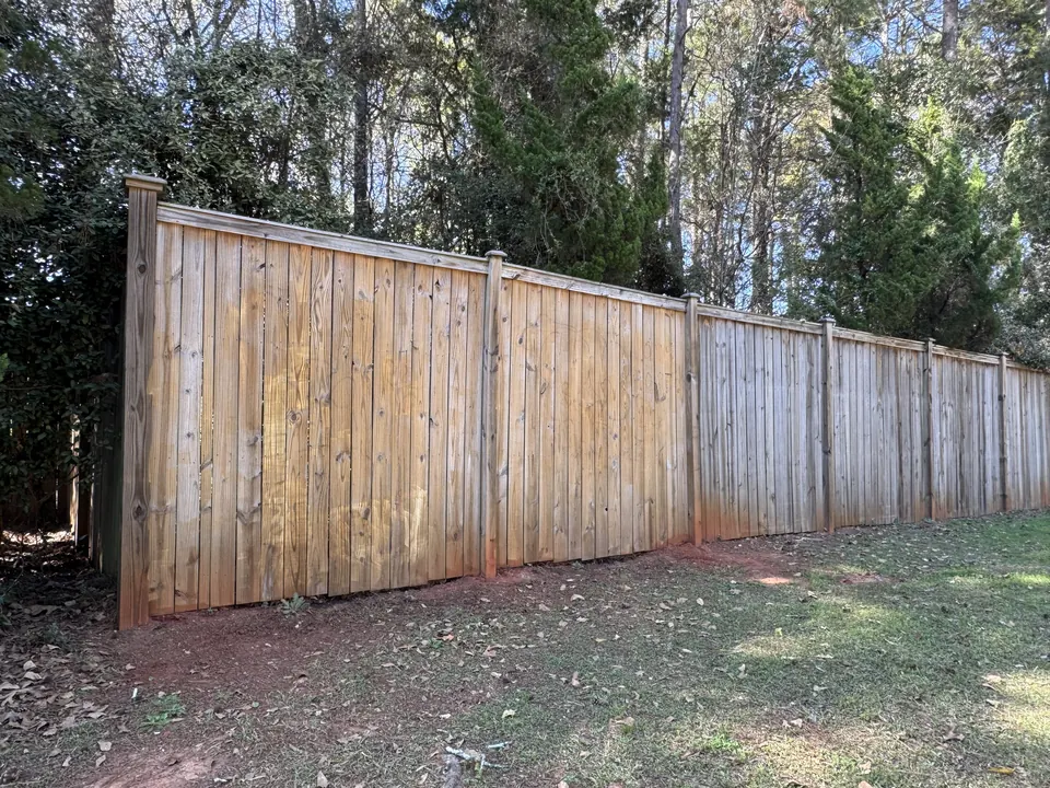 Wood privacy fence with warm natural color restored after cleaning