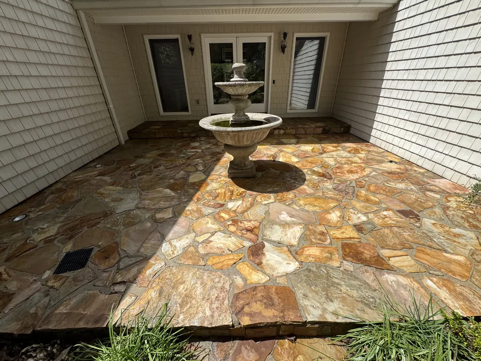 Same flagstone patio with warm golden color restored after cleaning