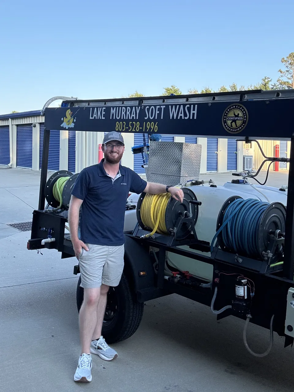 Matthew Caldwell, owner of Lake Murray Soft Wash, standing next to the company trailer