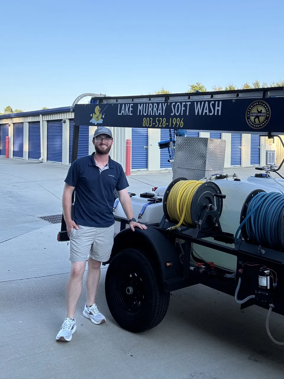 Matthew Caldwell, owner of Lake Murray Soft Wash, standing next to the company trailer