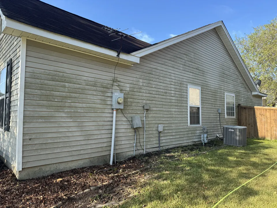 Vinyl siding with green algae streaks before a house wash