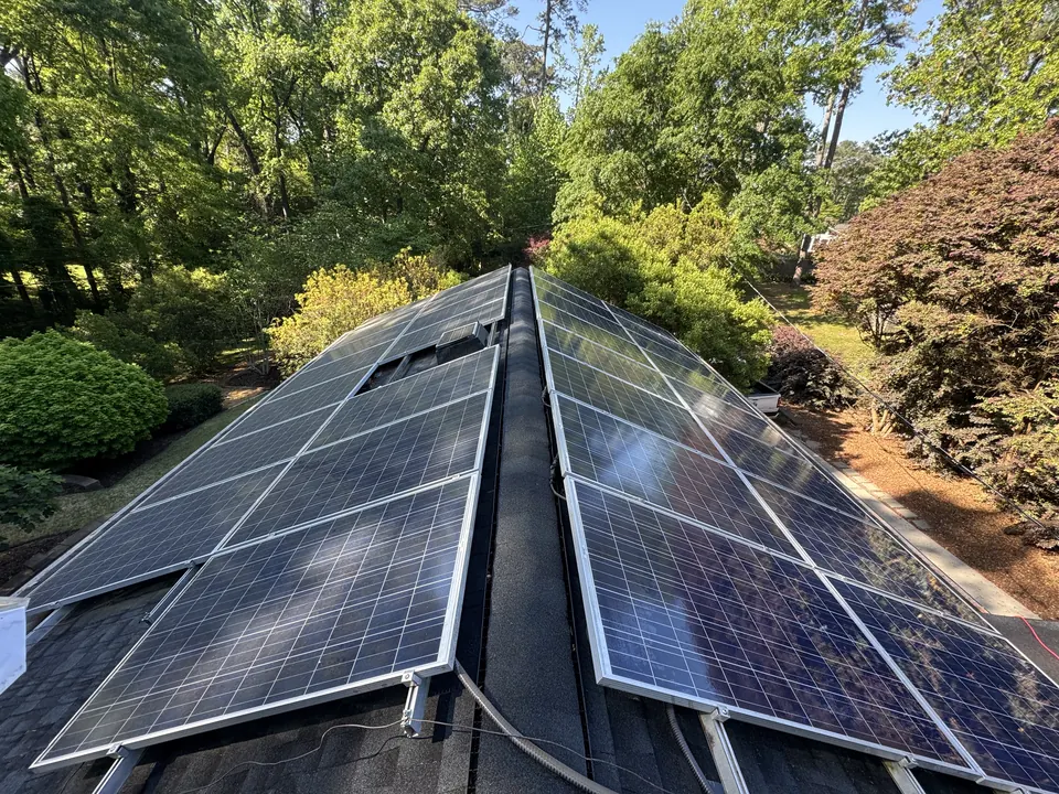 Roof-mounted solar panels with a dull, hazy film before cleaning