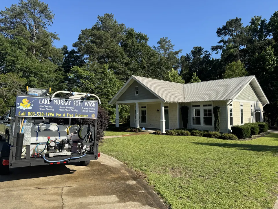 Lake Murray Soft Wash trailer beside a cottage with a metal roof